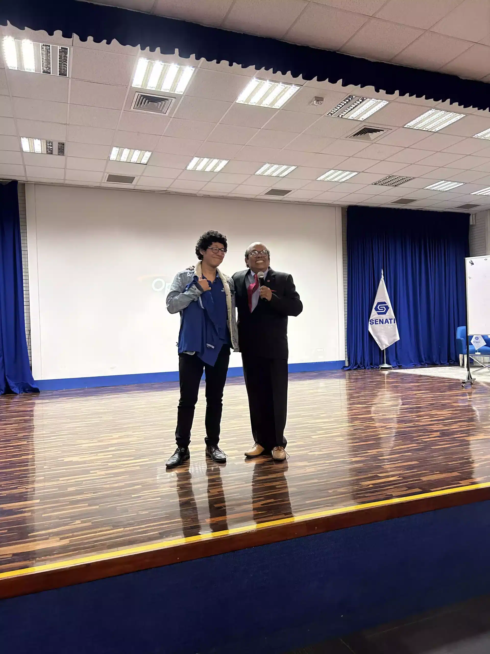 Juan Carlos Carrasco con un participante en el escenario