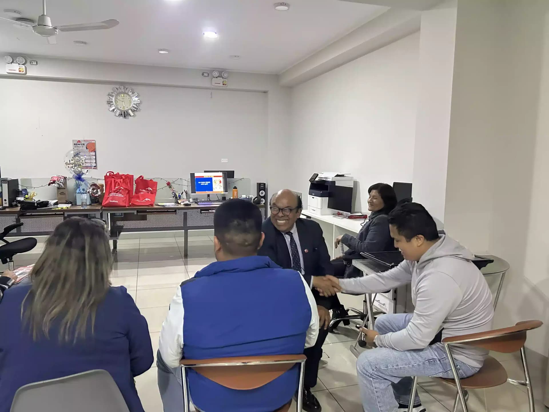 Juan Carlos Carrasco conversando con participantes en una oficina